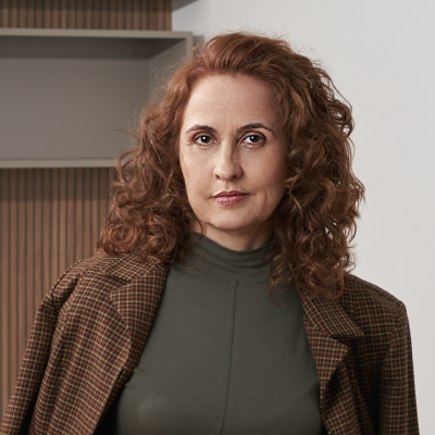 Dra. Elen Dias vestindo um traje formal com blazer.